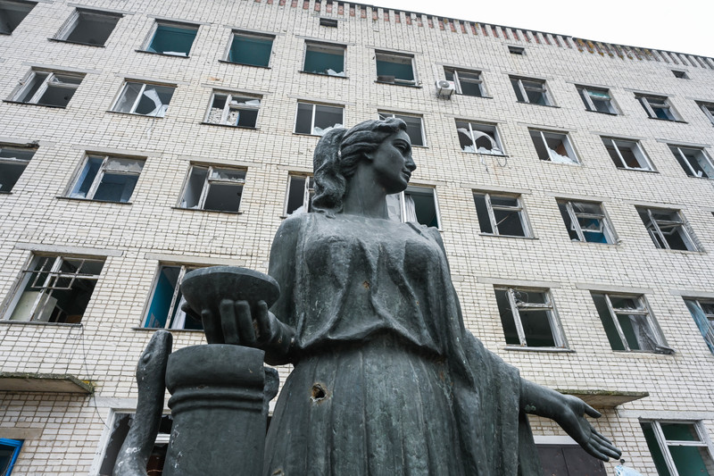 烏克蘭南部赫爾松州維索科皮拉（Vysokopilla）的醫院遭戰火破壞嚴重，院外雕像有著明顯彈孔痕跡。（攝影／Colin Delfosse）
