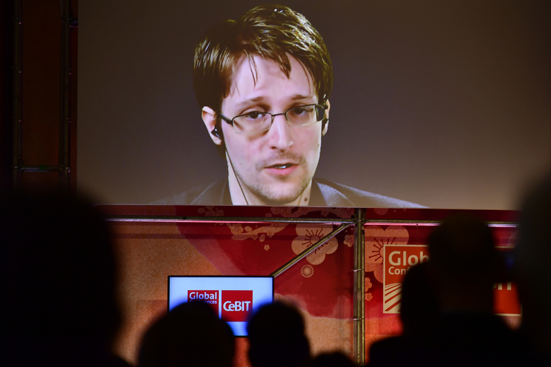 作為五眼聯盟的一員，除了能透過合作獲得情報共享，也得共同承擔遭遇滲透或洩密的風險。圖為2013年披露聯盟過度監視問題的史諾登（Edward Snowden），在資訊及通訊技術博覽會（CeBIT）上進行視訊演說。（攝影／Alexander Koerner／Getty Images）