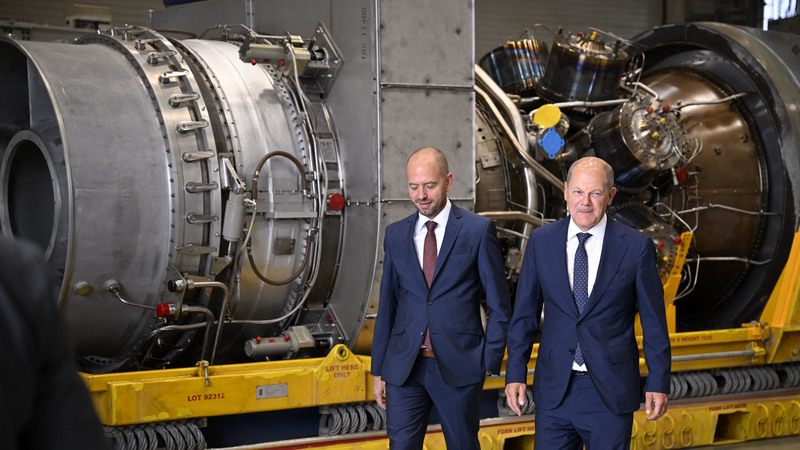 德國總理蕭茲（Olaf Scholz ，右）於西門子能源的參訪行程中經過「北溪一號天然氣管道」（Nord Stream 1）的渦輪機。（攝影／SASCHA SCHUERMANN／AFP）