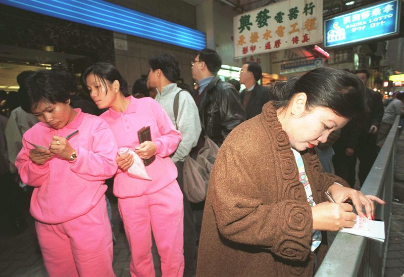 1990年代，香港市民在街頭排隊購買六合彩。（攝影／Anat Givon／AP Photo）