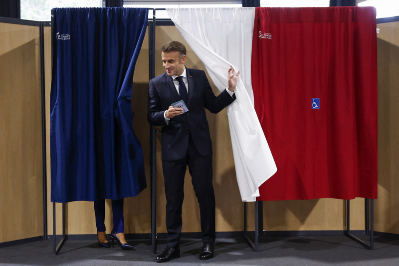 法國總統馬克宏在裝飾有法國國旗顏色的投票亭中投票。（攝影／MOHAMMED BADRA ／POOL ／AFP）