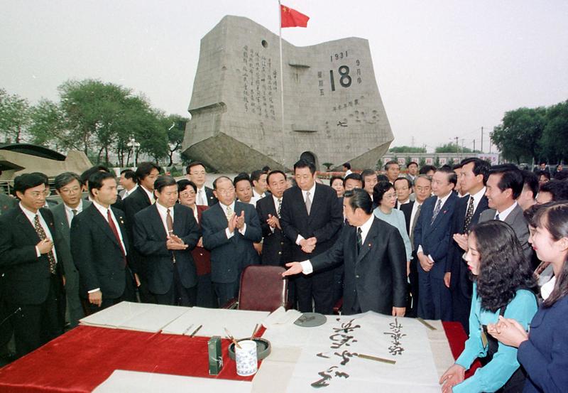 1996年9月6日，時任日本首相橋本龍太郎（中右，伸右手者）在參觀中國瀋陽的「九．一八歷史博物館」時，親筆手書「以和為貴」。（攝影／GOH Chai Hin／AFP）