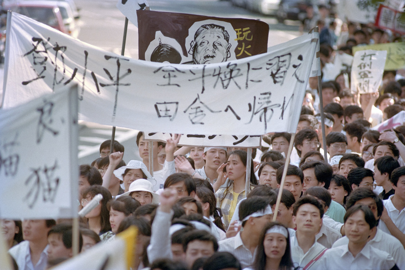 1989年6月4日當天，日本東京街頭上群眾聚集聲援北京學生，高舉旗幟標語：「鄧小平，學全斗煥（韓國軍事強人，1980～1988年統治韓國）回鄉下去吧！」（攝影／Junji KUROKAWA／AFP）