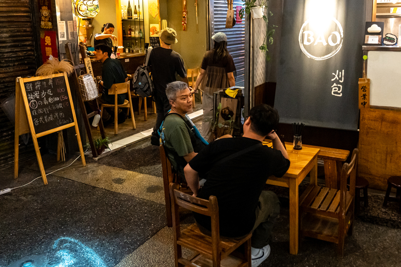 在「委託行街區」經營餐廳的張老闆（圖中）不諱言政治，經常和客人伴酒深聊至午夜。（攝影／陳曉威）