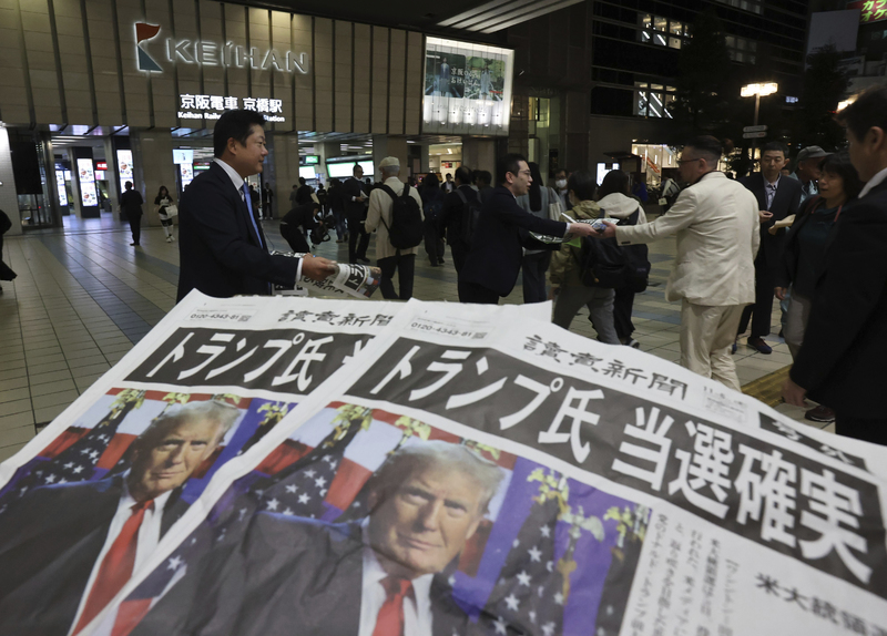 2024年11月6日，日本大阪民眾在街上收到號外的《讀賣新聞》，內容為川普於美國總統大選中獲勝。（攝影／The Yomiuri Shimbun via AP Images／達志影像）