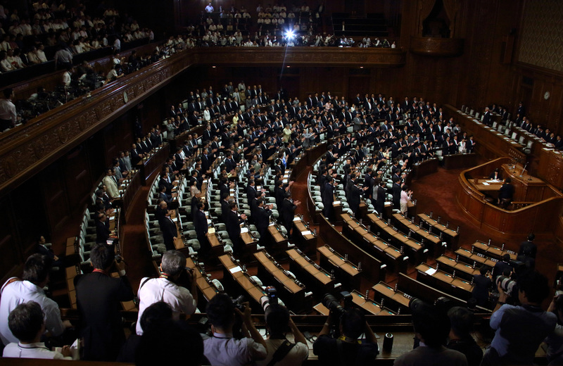 2015年7月16日，日本眾議院的國會議員們在法案宣讀通過時全體起立。每年上半年的國會議事會期，通常是霞關公務員最為痛苦的過勞地獄。（攝影／Tomohiro Ohsumi／Bloomberg via Getty Images）