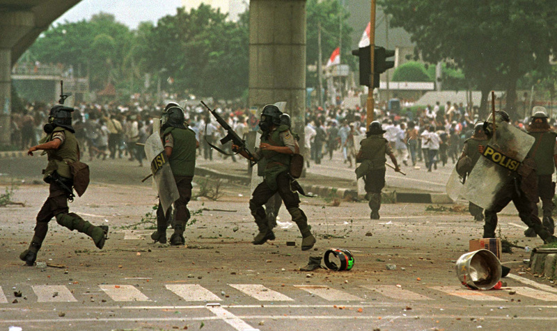 During the peak of the 1998 Asian financial crisis, Indonesia experienced the May 1998 Riots. The economic crisis and political instability fueled public frustration and anger, leading to continuous demonstrations demanding political reform and resulting in prolonged violent clashes. The image shows riot police in Jakarta, Indonesia, on May 15, 1998, chasing and dispersing protesters. (Photo by Paula Bronstein/Getty Images)