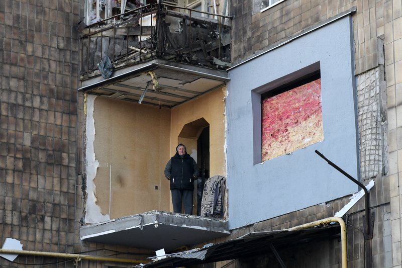 2月9日時，一名烏克蘭頓涅茨克地區馬基伊夫卡（Makiivka）鎮的當地居民站在遭俄羅斯炸毀的房屋陽台上。（攝影／STRINGER／AFP）