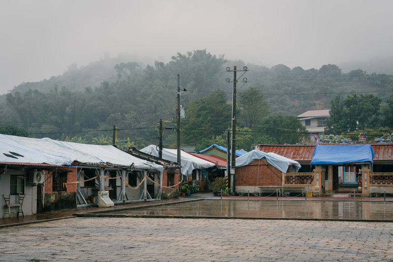 強震後，江家古厝居民以帆布覆蓋拜亭以及古厝屋頂，以免雨水從錯位的紅瓦間滲入，加劇老屋毀傷。（攝影／馬雨辰）